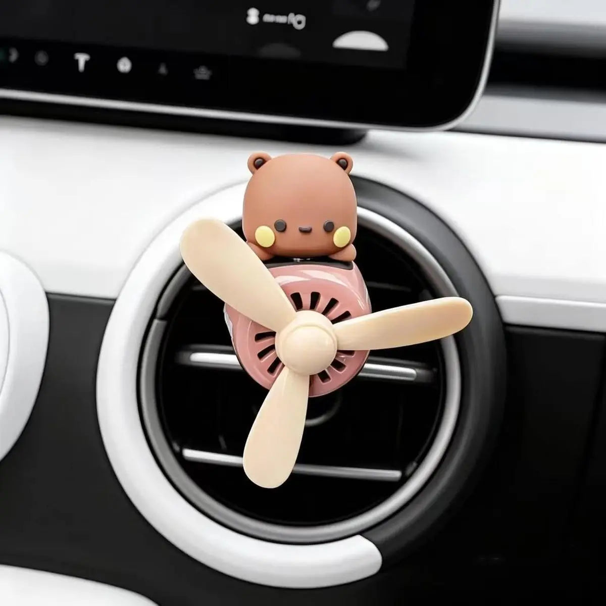 Brown bear airplane air freshener clipped to a car vent