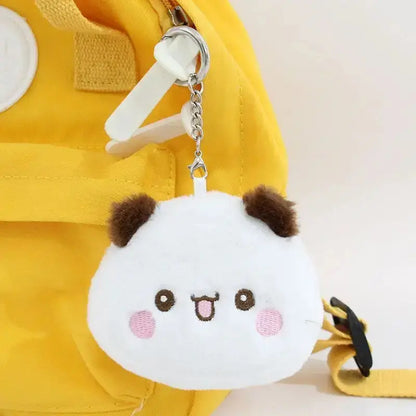 Cute Dudu and Bubu coin wallet keychain attached to a yellow bag, featuring a smiling, fluffy character design.